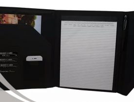 Black leather portfolio organizer with notepad, card slots, and pen.
