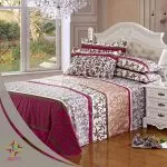 Ornate magenta and brown patterned luxury bed sheets with a white tufted headboard.