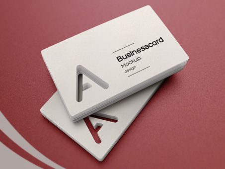 Premium die-cut business card mockup design on a maroon background.