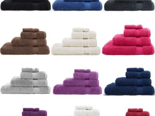 Twelve stacks of colorful, folded bath towels showcasing various shades against white.