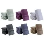 Six stacks of plush, colorful terry cloth towels in white, mint, and purple.