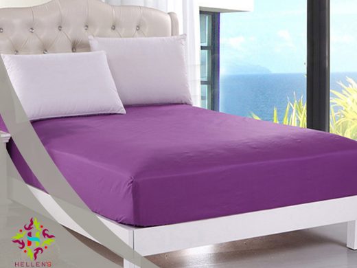 Vibrant purple linen on a luxurious bed with an ocean view.