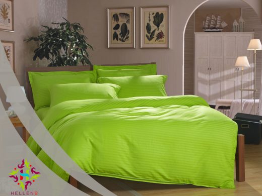 Vibrant lime-green striped linen on a modern bed with botanical art.