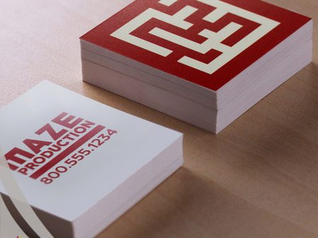 Square printed business cards showcasing red maze design and MAZE PRODUCTION logo.