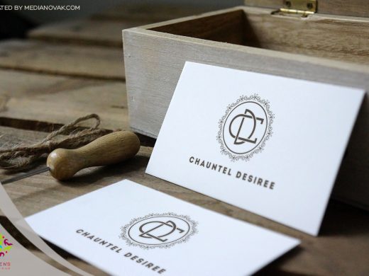 Elegant white business cards for Chauntel Desiree on rustic wood.