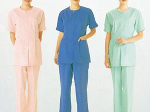 Three models wearing pink, blue, and green medical scrub uniforms with caps.