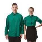 Smiling hotel staff in matching emerald green uniform shirts and black aprons.