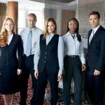 Professional hotel staff in business attire standing on patterned carpet.