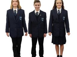 Three students in navy blue school uniforms with blazers and ties.
