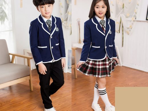 Young students in formal navy blue school uniforms with plaid skirts and blazers.
